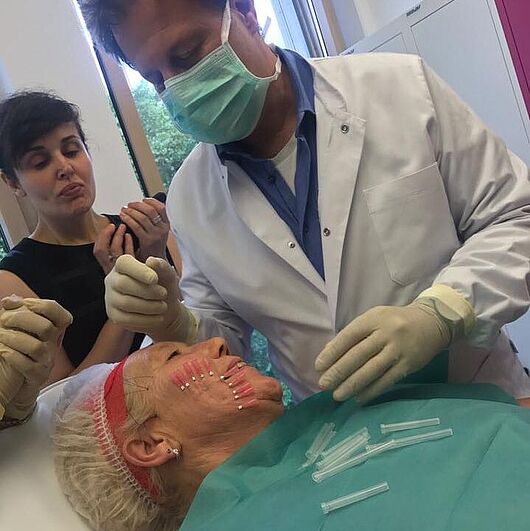 Dr. Schuhmann bei der Fadenlifting Behandlung. Patientin mit PDP Fäden in der Wange.